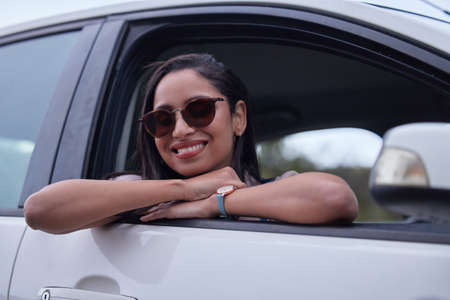 Im enjoying every minute of this road trip. a young woman leaning out a car window while on a road...