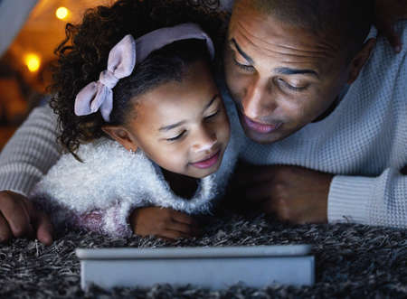 Teach them lots, love them always. an adorable little girl using a digital tablet with her father...