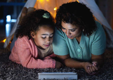 A fairytale for the digital age. an adorable little girl using a digital tablet with her mother...