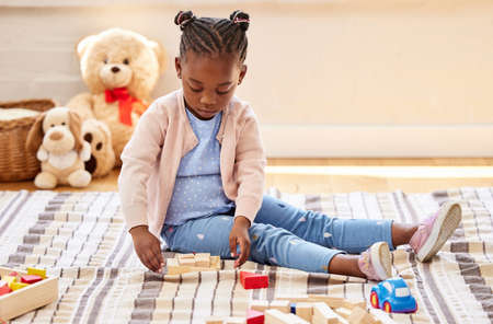 Learning with the help of blocks. a little girl playing in her room at home.の写真素材
