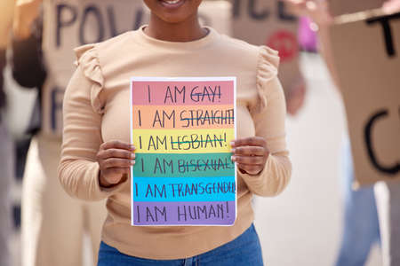 Love is a human condition. a woman holding up a sign at an lgbtq rally.の写真素材