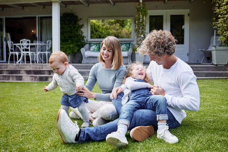His precious little steps. a young family bonding with each other and playing in their garden at home.の写真素材
