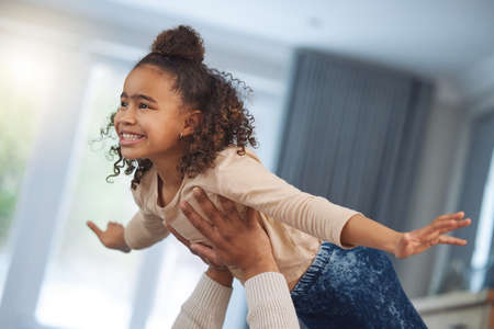 Today we play, tomorrow we pilot. an adorable little girl playing with her father at home.