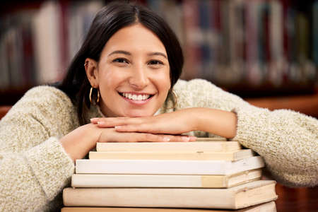 I got everything done. a young female student studying in a library at college.