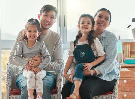 Home is a feeling not a place. Shout of a couple sitting at home with their two daughters.