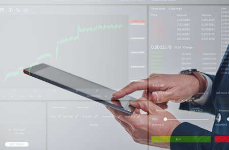 Making the best trades. Closeup shot of an unrecognisable businessman using a digital tablet while...