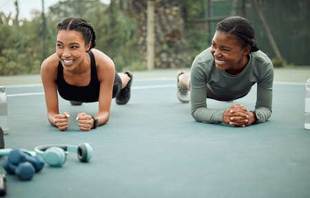 Lets see who can hold out. Full length shot of two attractive young female athletes planking while...