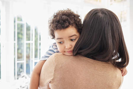 Get your hugs in while theyre still young. a mother embracing her sad son at home.