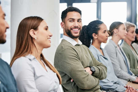 Hes loving this presentation. a handsome young businessman sitting with his arms folded in the...
