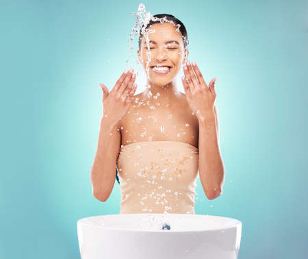 Fresh and invigorated - Beauty. a young woman doing her daily skincare routine against a blue...