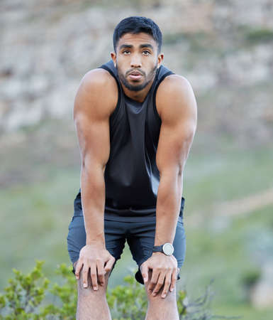 Phew, this workout is kicking my butt. a handsome young man taking a moment to catch his breath...