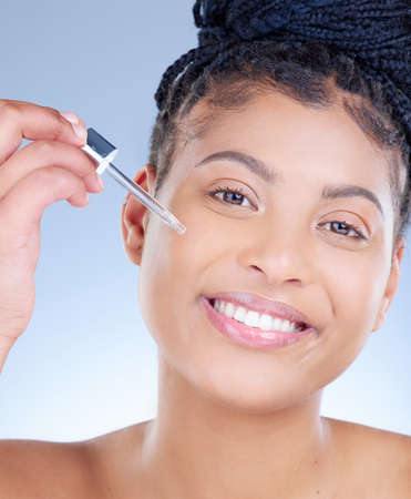 The smoothest application. Studio portrait of an attractive young woman applying serum to her face...