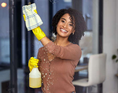 If you can see me clearly, my job is done. a young woman cleaning windows at home.