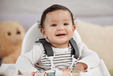 A baby girl is a bundle of firsts that excite. a baby playing with blocks at home.