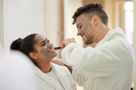 Make sure you get it everywhere. a young couple having a spa day at home.