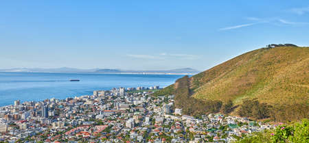 Panoramic shot of a coastal city at the bottom of a hill. The central business district of Cape Town, South Africa, A picturesque horizon showing both land and city, as well as a commercial areaの写真素材