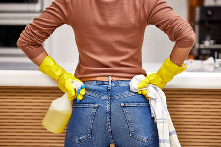 Ready to tackle this kitchen. a woman taking a break while cleaning her kitchen.の写真素材