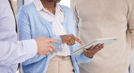 Your work has been impressive. a group of business people using a digital tablet during a meeting.