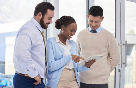 Im proud of you. a group of business people using a digital tablet during a meeting.