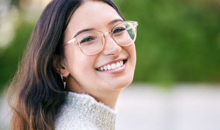 Keep smiling, the world needs it. a happy young woman standing outside.