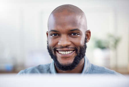 The starting point of all achievement is desire. a young businessman using a laptop in a modern office.の写真素材
