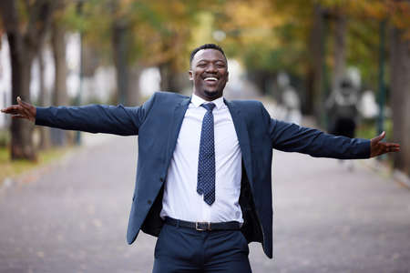 Feel joy in every moment. a young businessman standing in the street in the city.の写真素材