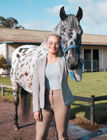 I think he likes me. Portrait of an attractive woman posing with a horse in an enclosed pasture on a...