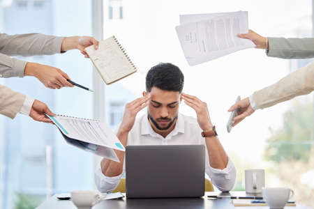 I just want to be left alone. a young businessman looking stressed at work.