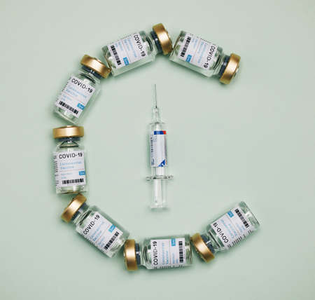 Each vaccine is handled with care. vaccines and a syringe against a green background.の写真素材