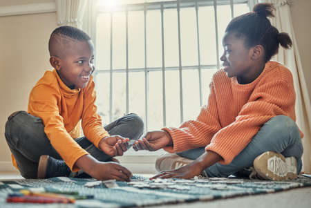 You can build this piece. a brother and sister building a puzzle together at home.の写真素材