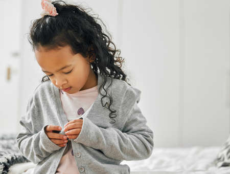 I wouldnt want to get cold. a little girl getting dressed at home.