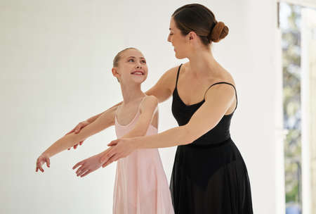 Staying engaged, motivated and inspired. a young girl practicing ballet with her teacher in a dance...