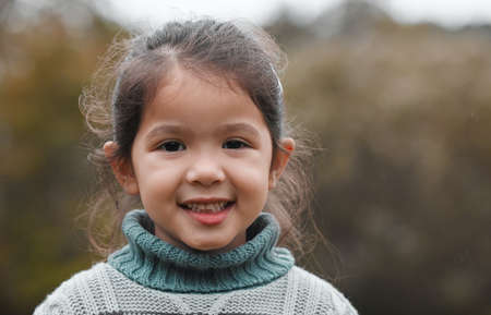 The park is my favourite place to be. an adorable little girl standing alone in the park.