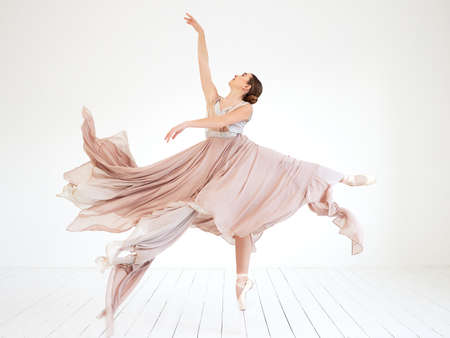 Shes got a rehearsal coming up. Full length shot of an attractive young female ballerina practicing in her dance studio.の写真素材