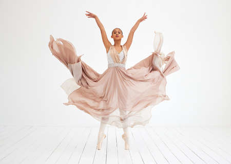 Where the magic happens. Full length shot of an attractive young female ballerina practicing in her dance studio.の写真素材