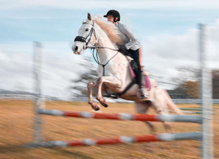 Once you build trust, you will soar. a young rider jumping over a hurdle on her horse.