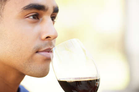 You can tell a lot about a wine by its aroma. Closeup shot of a handsome young man enjoying some...