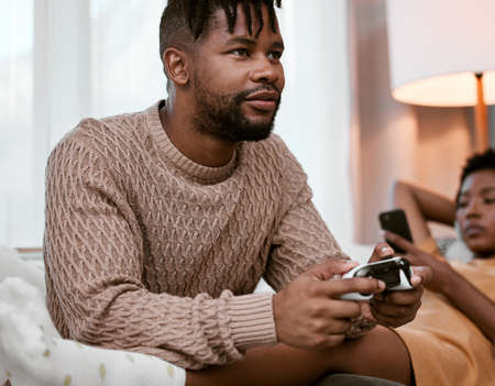 Gaming allows you live more than one life. a handsome young man playing video games while relaxing...