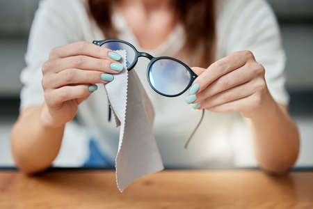 Lets get them crystal clear. an unrecognizable person cleaning glasses at home.の写真素材