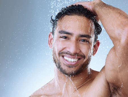 May peace prevail. Portrait shot of a handsome young man enjoying a shower against a grey background.の写真素材
