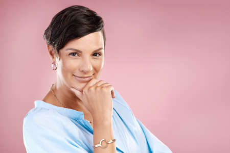 How you doing. Cropped portrait of an attractive young woman posing in studio against a pink...