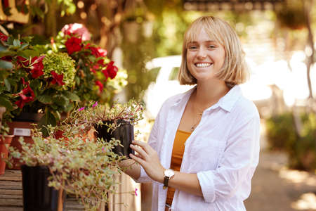 Im always happy when Im out shopping for plants. a beautiful young woman out shopping for plants.の写真素材