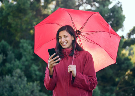 With us, youre covered wherever you do. a woman using her cellphone while walking outside with an...