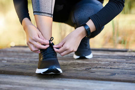 I have goals to chase after. Closeup shot of an unrecognisable woman tying her laces while...