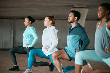 Taking our workout to the next level. a group of friends practicing lunges outside together.