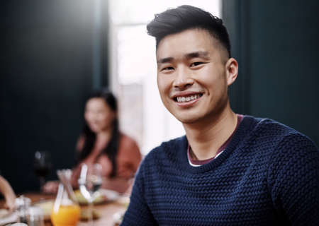 Portrait of a handsome young man having a meal with his wife at home.の写真素材