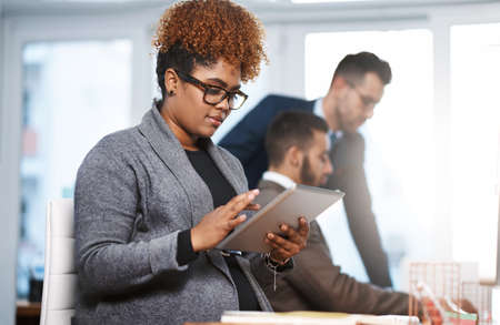 an attractive young businesswoman working at her desk in a modern office.の写真素材