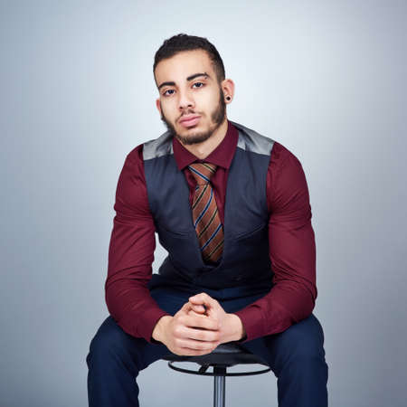 Studio shot of a handsome young businessman posing against a grey background.