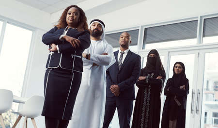 They deal in success. Low angle shot of a diverse group of business colleagues standing in a single...