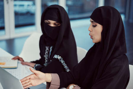 Theyre just a plan away from success. two young arabic businesswomen working on a laptop in their office.の写真素材